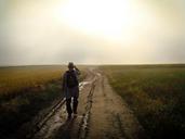 Person_with_Hat_and_Backpack_Walking_on_Trail.jpg