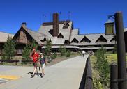 Old_Faithful_Inn,_visitors_walking_on_sidewalk_behind_the_Inn.jpg