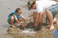 Father and son playing at beach making sand castle.jpg