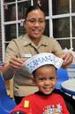 US_Navy_090727-N-1783P-001_Hospital_Corpsman_2nd_Class_Reneline_Llamas,_assigned_to_Naval_Health_Clinic_Charleston,_places_a_decorated_white_Sailor's_hat_on_a_4-year-old_patient.jpg