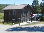 Old_Faithful_Lodge,_housekeeper_walking_in_front_of_a_cabin.jpg