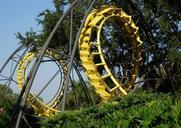 A yellow roller coaster track set amid trees.jpg