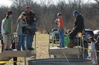 An event leader helps an archery student practice her skills.jpg