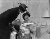 Centerville,_California._Mother_and_baby_await_evacuation_bus._Posted_on_wall_are_schedules_listin_._._._-_NARA_-_537581.jpg