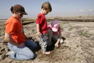 A young boy helps his sister mother and the girl scouts plant trees.jpg