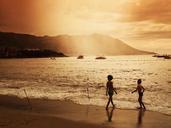 Children_on_Beach_with_Boats_in_Water.jpg