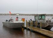 Employees working with ribal partners secure boats and check nets.jpg