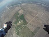 Hand-mounted skydiving altimeter with analogue display being used in free fall.jpg